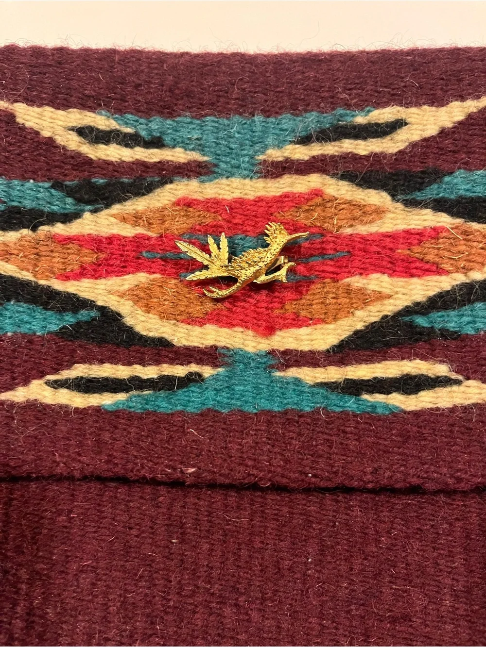 Woven burgundy and earth tone fold over clutch with antique gold tone pin